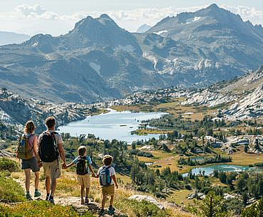 Family hiking above the Sky High Lakes Basin in the Marble Mountains California on a scenic alpine trail.