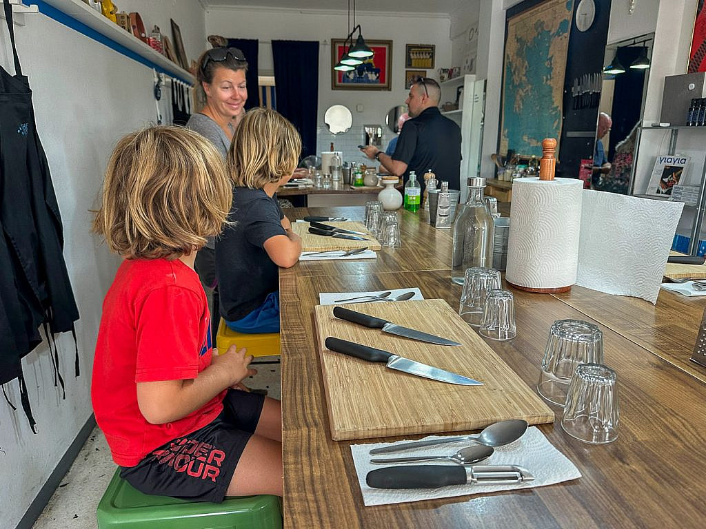 Participants gathered around the kitchen island during The Greek Kitchen Athens cooking class before beginning to prepare traditional Greek recipes.