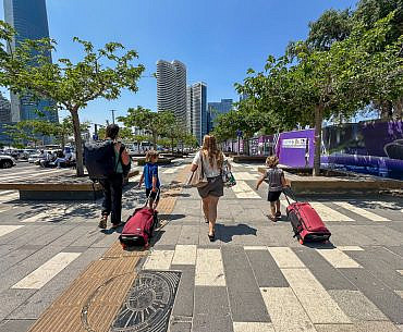 Family traveling through a European airport with BAGSMART Roll & Roam kids carry-on luggage during a Europe and Middle East trip