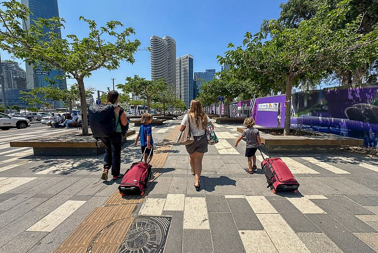 Family traveling through a European airport with BAGSMART Roll & Roam kids carry-on luggage during a Europe and Middle East trip