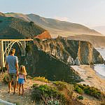 Family overlooking Bixby Creek Bridge in Big Sur during a Pacific Coast Highway road trip with kids.