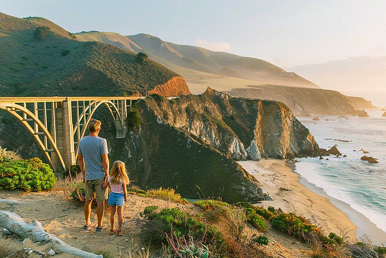 Family overlooking Bixby Creek Bridge in Big Sur during a Pacific Coast Highway road trip with kids.