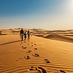 Family walking through Al Marmoom Desert Conservation Reserve, one of the outdoor things to do in Dubai with kids.