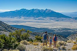 Family overlooking Wheeler Peak and the Snake Range during a Great Basin National Park with kids trip.