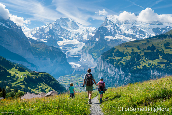 Family hiking in Europe on an alpine trail near Wengen in the Bernese Oberland, Switzerland.
