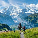 Family hiking in Europe on an alpine trail near Wengen in the Bernese Oberland, Switzerland.