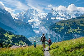 Family hiking in Europe on an alpine trail near Wengen in the Bernese Oberland, Switzerland.