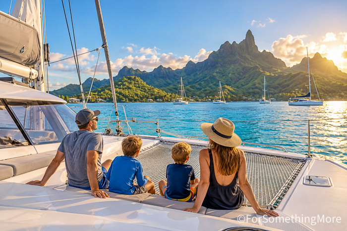 Large sailing catamaran cruising through turquoise water during a family bluewater sailing trip.