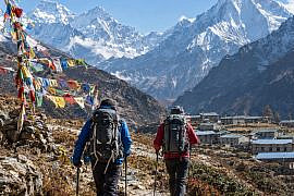 Experienced hikers trekking through the Himalayas in Nepal.